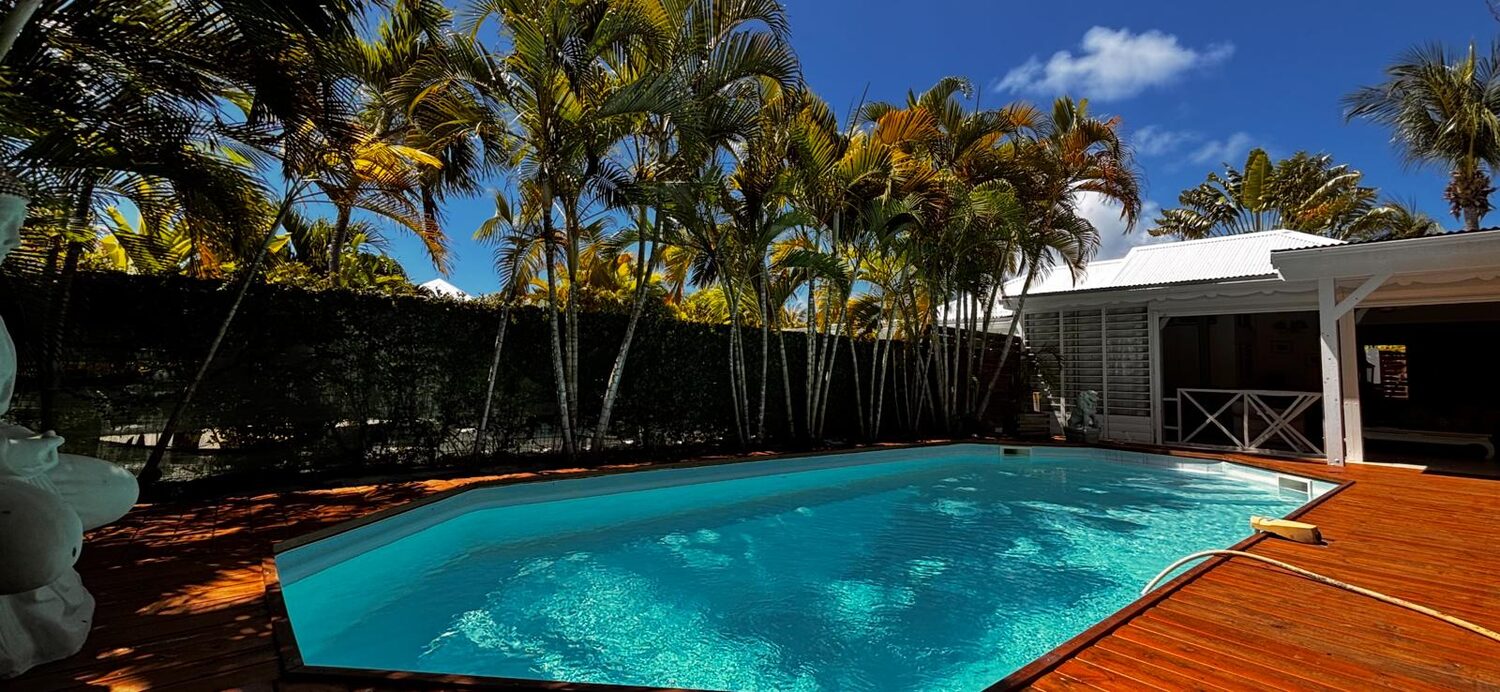 Piscine privée et villa créole Beijaflor entourées de palmiers à Saint-François